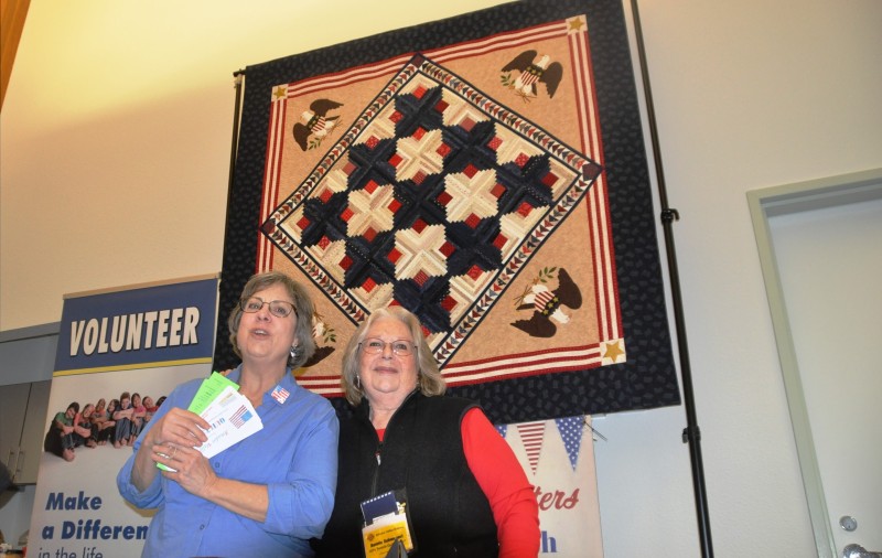 Exhibitors with a beautiful patriotic quilt