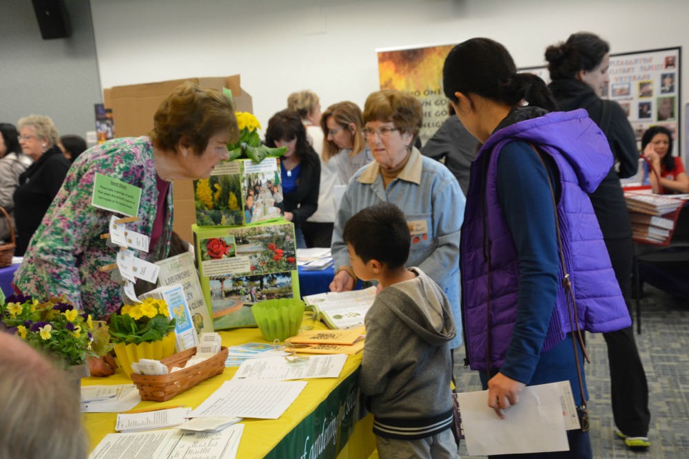 Woman at the Make A Difference Festival in Pleasanton CA explaining gardening to a young boy